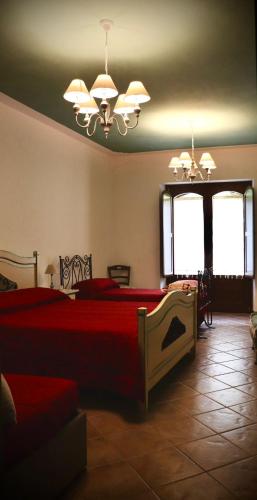 a bedroom with a red bed and two windows at Villa Manca in San Severino Lucano
