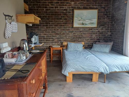 a bedroom with a bed next to a brick wall at BosSpoke Bush Lodge in Thabazimbi