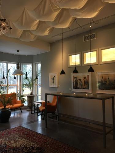 a living room with a table and pendant lights at Karstorp Säteri – Hotell och Konferens in Skövde