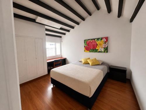 a bedroom with a bed in a white room at Hostel Casa Unicentro in Bogotá