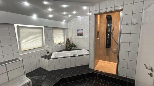 a large bathroom with a tub and a shower at Apartment Grieshop in Dinklage