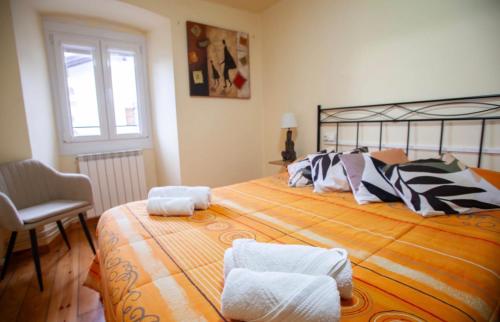 a bedroom with a large bed and a chair at Posada de Labaien in Beinza-Labayen