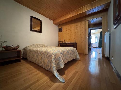 a bedroom with a bed and a wooden floor at Casa Camomilla in Creto
