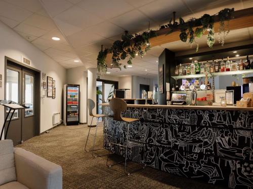 a bar with a black and white wall at ibis Brussels Waterloo in Waterloo