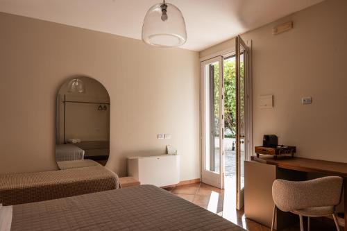 a bedroom with two beds and a mirror and a window at B&B Villa Giuliana in Arnesano
