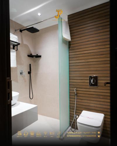 a bathroom with a toilet and a cross on the wall at Al jadriya Palace in Baghdād