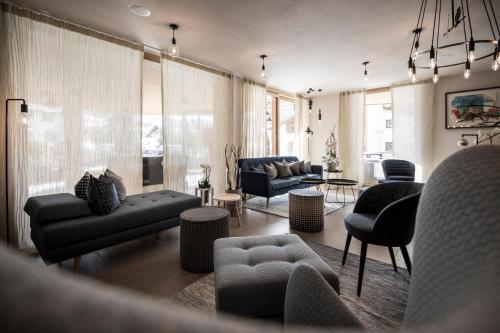 a living room with a couch and chairs and a table at Hotel Tofana in San Cassiano