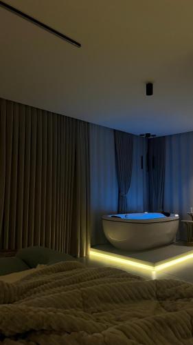 a bedroom with a tub in a room with a bed at Cabana No Lago in Rancho Queimado