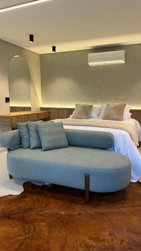 a bedroom with a blue couch in front of a bed at Cabana No Lago in Rancho Queimado