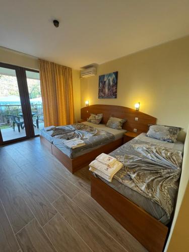 a hotel room with two beds and a balcony at Sunny Paradise Family Hotel in Kiten