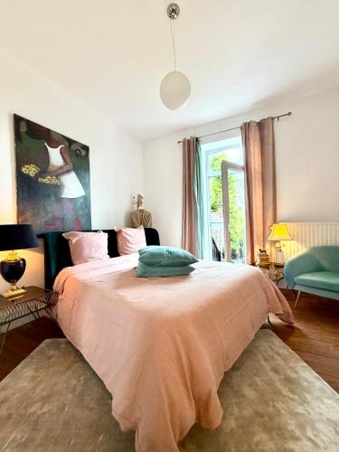 a bedroom with a large bed with a pink blanket at Maison VCB Ciney - Hôtel Particulier de 1820, Cœur de Ville, Parc & Parking Privé in Ciney