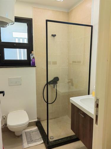 a bathroom with a shower and a toilet and a sink at Zahra-Northed Chalet in El Alamein