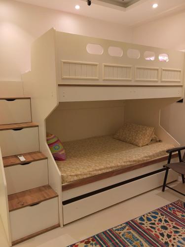 a bunk bed in a room with a rug at Zahra-Northed Chalet in El Alamein