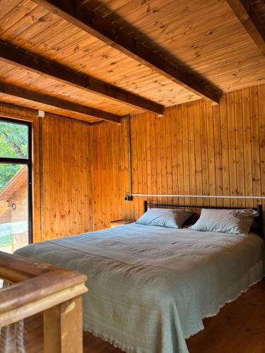 a bedroom with a bed in a wooden wall at Babitouli-1 in Niabauri
