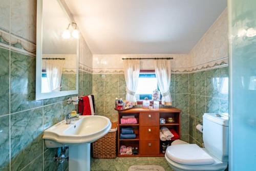 a bathroom with a sink and a toilet at Casa do Alto in Recarei