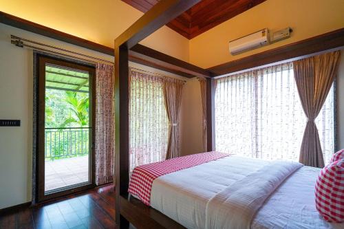 a bedroom with a bed and a large window at Open Hotel by Olive - Biranji Aqua Reatreat in Chikmagalūr