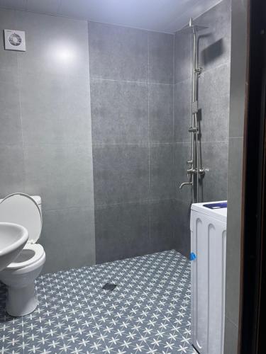 a bathroom with a toilet and a sink and a shower at Babitouli-2 in Niabauri