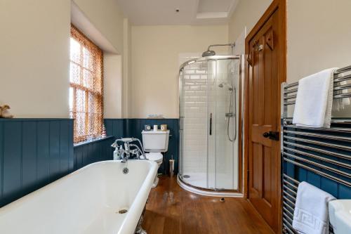 a bathroom with a bath tub and a shower at Corner House - Elie & Earlsferry in Elie