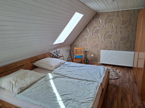 a attic bedroom with two beds and a skylight at Ferienwohnung am Vogelsteig in Pegnitz