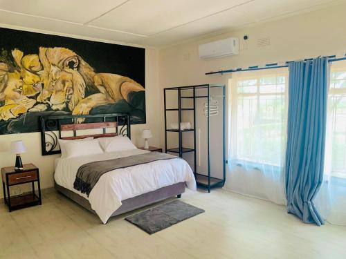 a bedroom with a tiger painting on the wall at Larry's Lodge in Livingstone