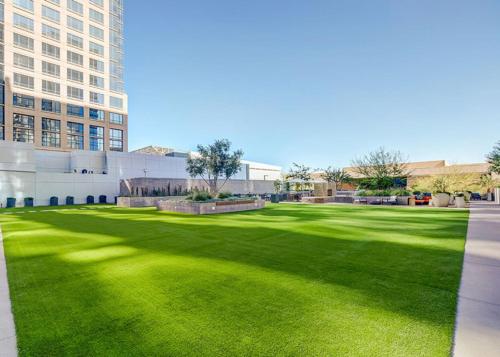a green lawn in front of a building at CozySuites at Adeline in Phoenix
