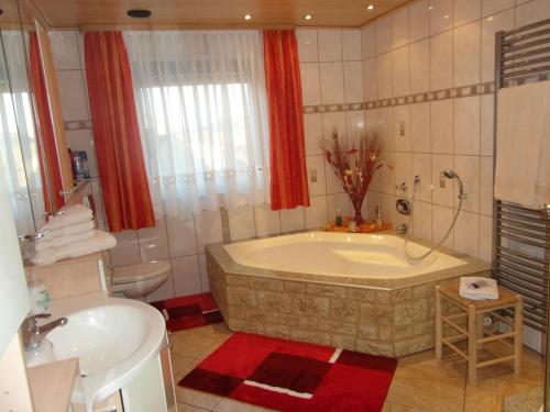 ein Badezimmer mit einer Badewanne, einem WC und einem Waschbecken in der Unterkunft Schönberger-Hof in Wernberg-Köblitz