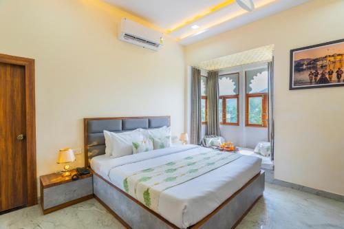 a bedroom with a large bed and a window at Manas Resort Udaipur in Udaipur