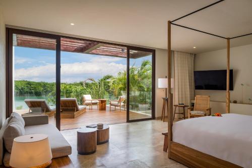 a bedroom with a bed and a living room at Rosewood Mayakoba in Playa del Carmen
