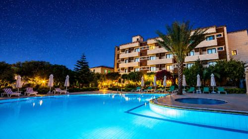 a swimming pool in front of a hotel at night at ANADOL Hotel & Pool Central Kyrenia in Temblos