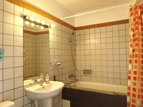 a bathroom with a sink and a mirror and a tub at Centrul 3H in Sub Piatra