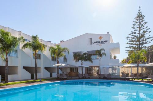 a hotel with a swimming pool in front of a building at Lagoa Hotel in Lagoa