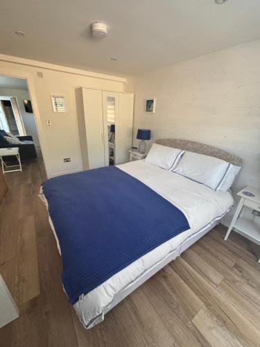 a bedroom with a large bed with a blue blanket at Mudeford Breeze in Mudeford