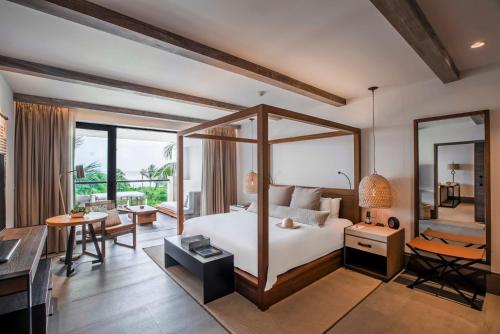 a bedroom with a bed and a desk and a room at Unico Hotel Riviera Maya Adults Only in Akumal