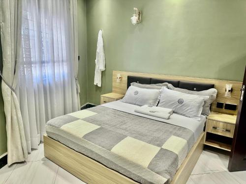 a bedroom with a large bed with green walls at El Gado Casas in Kampala