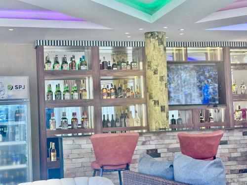 a bar with two chairs and bottles of alcohol at El Gado Casas in Kampala