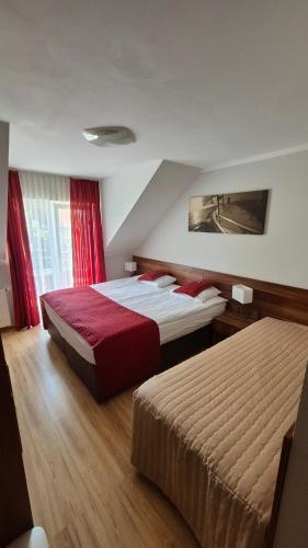 a hotel room with two beds and a window at Villa Maritima in Grzybowo