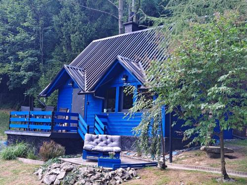 a blue house with a chair in front of it at Modry Domek Szczyrk domek na wyłączność z kominkiem in Szczyrk
