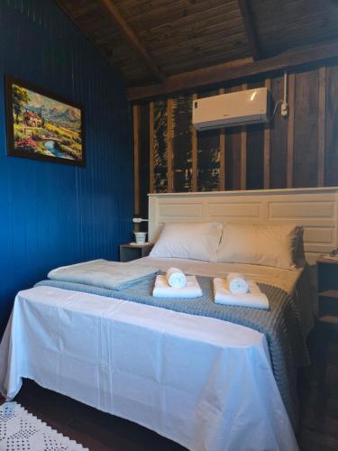 a bedroom with a bed with two towels on it at Vila dos Tropeiros in Lauro Müller