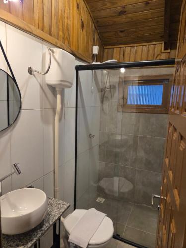 a bathroom with a shower and a toilet and a sink at Vila dos Tropeiros in Lauro Müller
