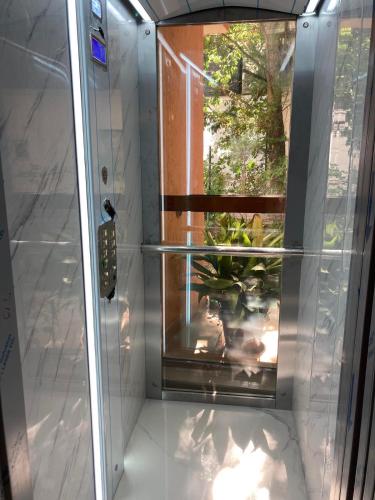 a shower with a glass door with a plant in it at Sunny Paradise Family Hotel in Kiten