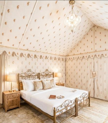 a bedroom with a bed and a ceiling with a chandelier at Yatra Desert Camp & Resort in Jaisalmer