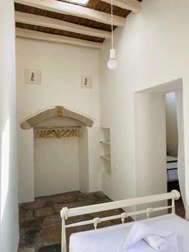 a bedroom with a bed and a stone fireplace at Matsipeti in Kythira
