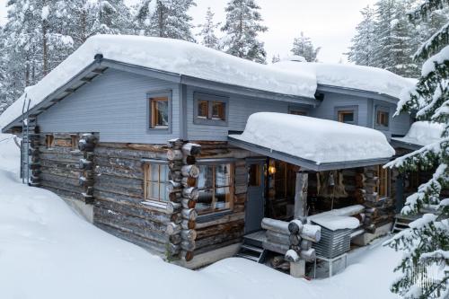 a log cabin with snow on the roof at HilleVilla by Holiday in Lapland in Ylläsjärvi