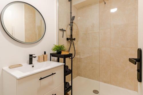 a bathroom with a shower and a sink and a mirror at Appartement refait à neuf, 4 pers à Courseulles in Courseulles-sur-Mer