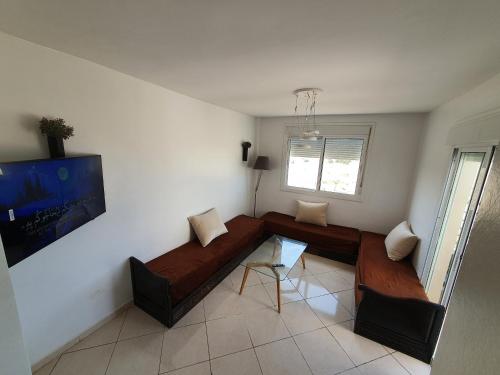 a living room with a couch and a tv at la vue coucher de soleil in Hauara