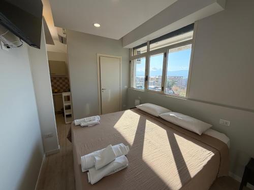 a bedroom with a large bed with two towels on it at MONTREAL FLAT STUDIO in Reggio di Calabria