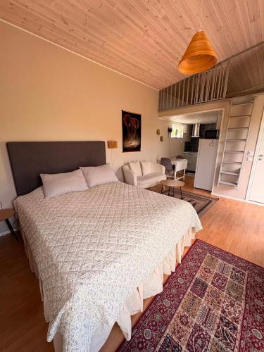 a bedroom with a large bed and a living room at Stugan i Vik på Österlen in Simrishamn