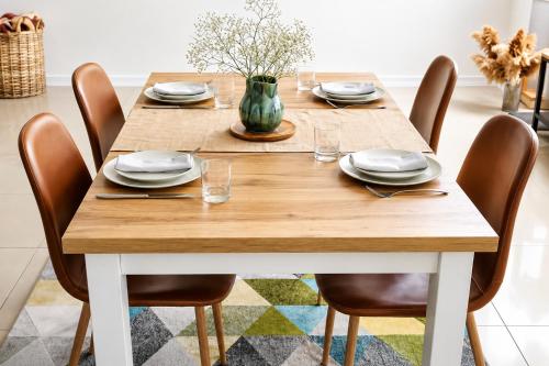 a wooden table with chairs and a vase on it at Optizee Hotel and Suites in Agege