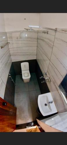 a small bathroom with a toilet and a sink at Palazhi Inn in Trivandrum