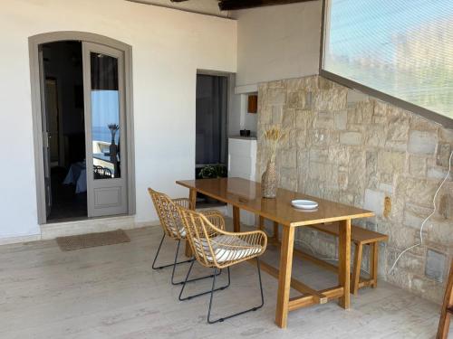 a dining room with a wooden table and chairs at Meteoron Platanias in Platanias